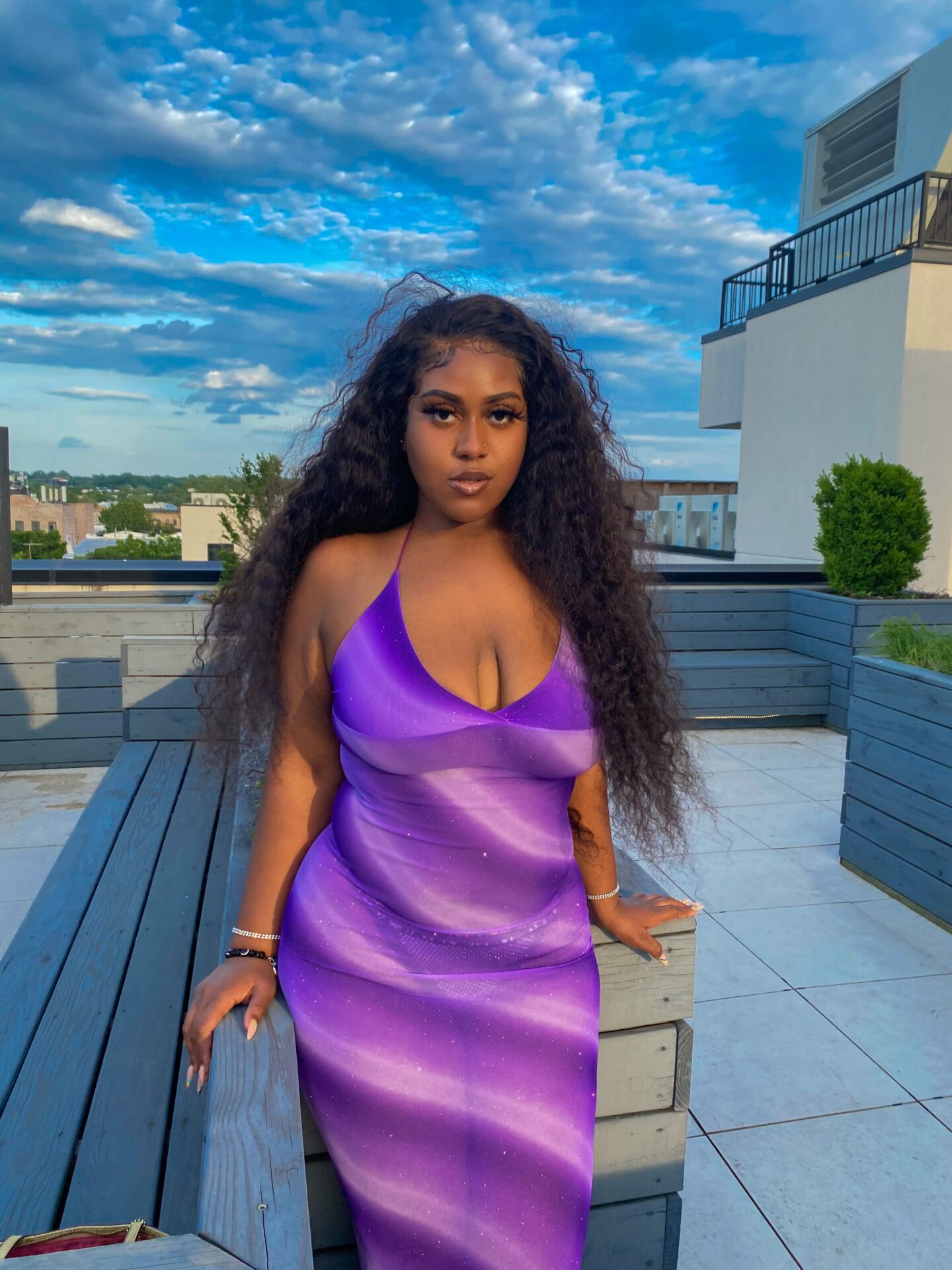 ZoAnne wearing a sheer, mesh purple swirl tank dress posing on top of a rooftop at a friend's birthday party.
